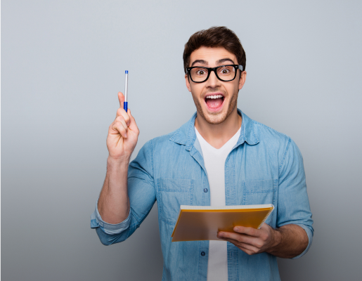 un jeune homme de face tenant un cahier et un stylo  sourit et s'exprime