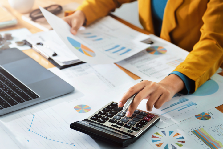 calculatrice sur un bureau avec dossiers et ordinateur